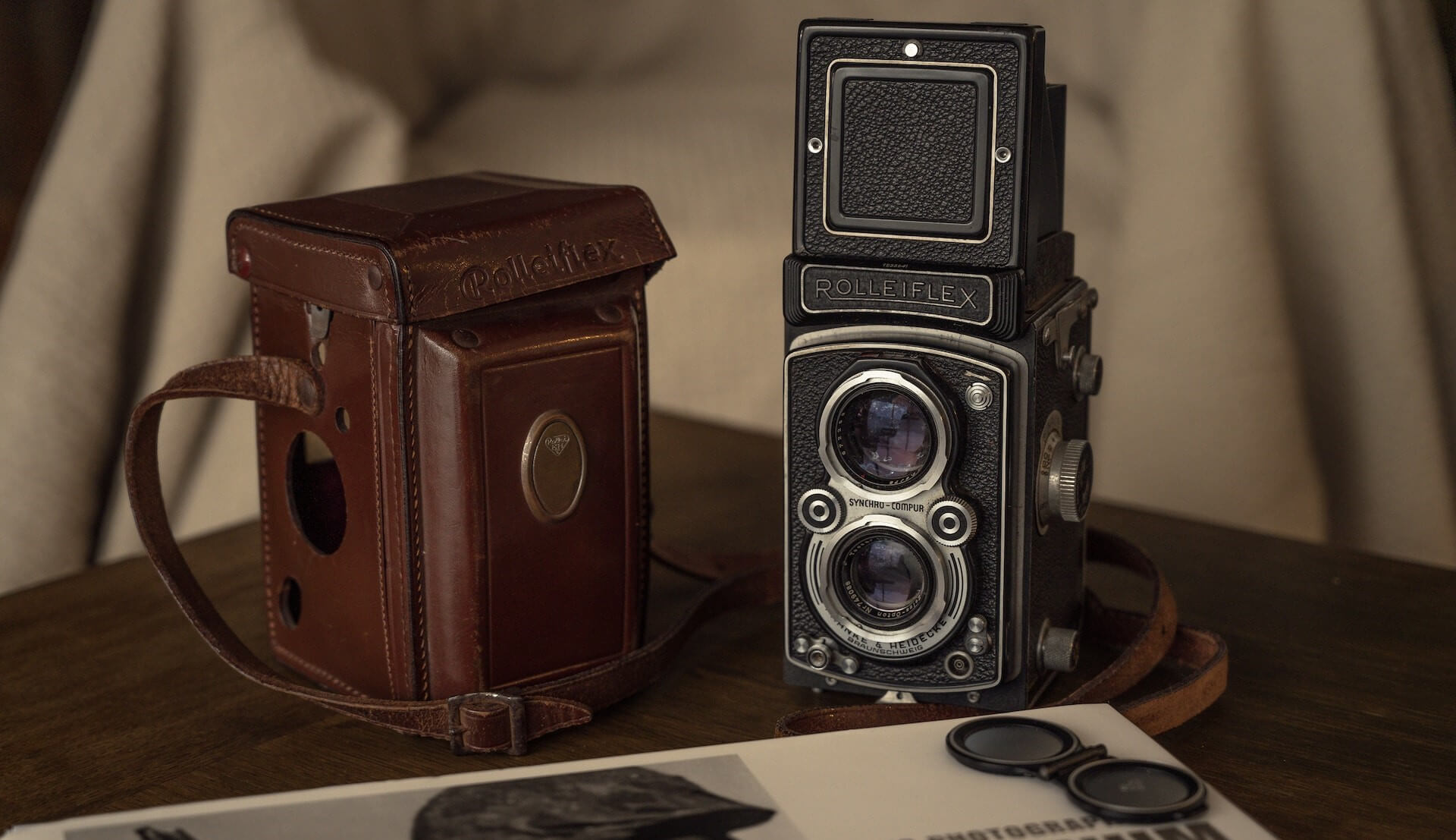 Vintage Rolleiflex twin lens camera with a protective leather case.